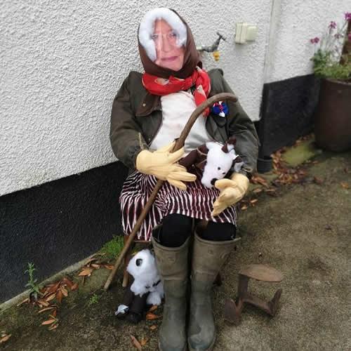 Photo Gallery Image - 'The Queen' in country attire with a crook sitting by a cottage wall